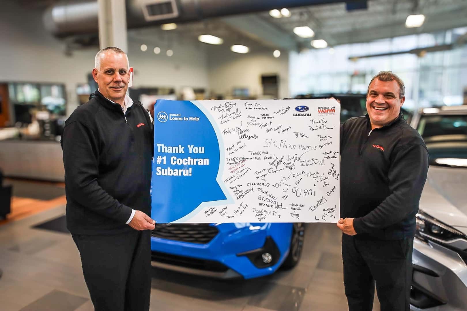 Two men holding Promotional sign