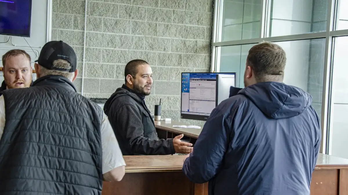 A pair of Albany Toyota employees helping customers at the front desk