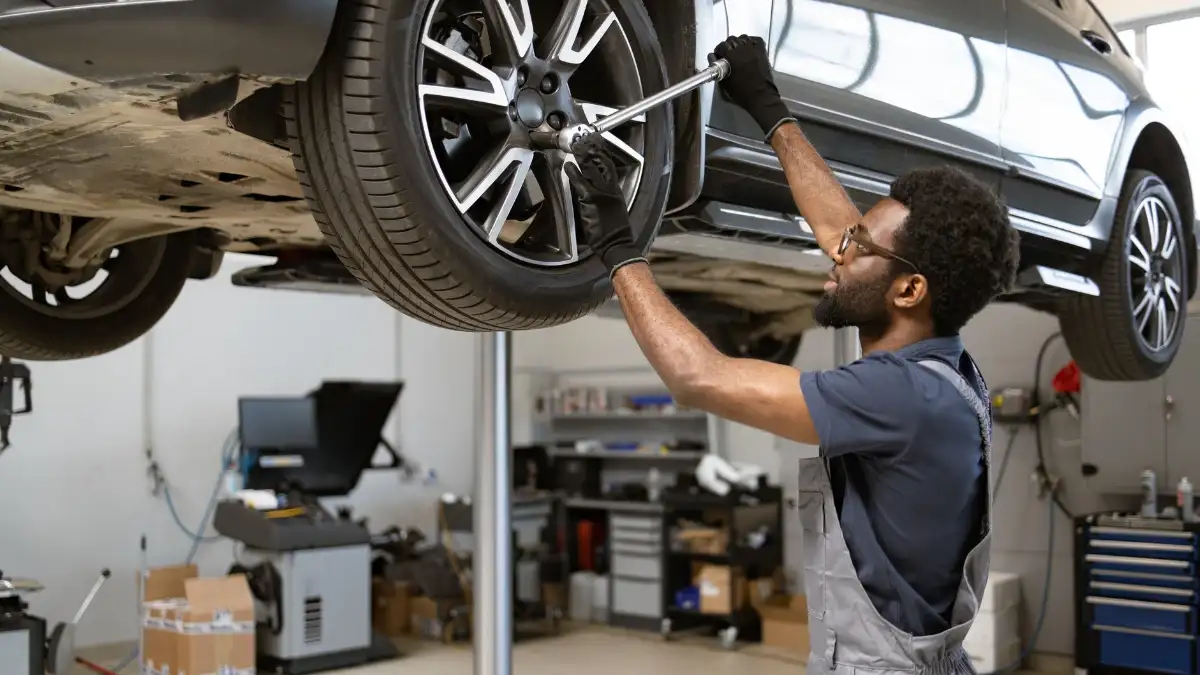 A mechanic working on a car on a raised platform