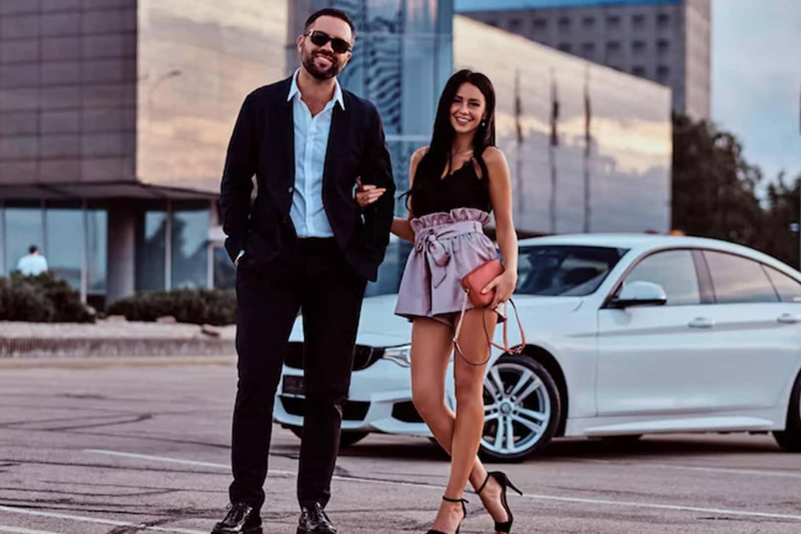 happy couple next to car