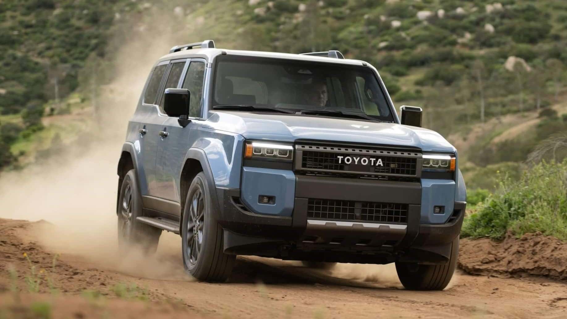 Toyota Land Cruiser driving down a dirt road