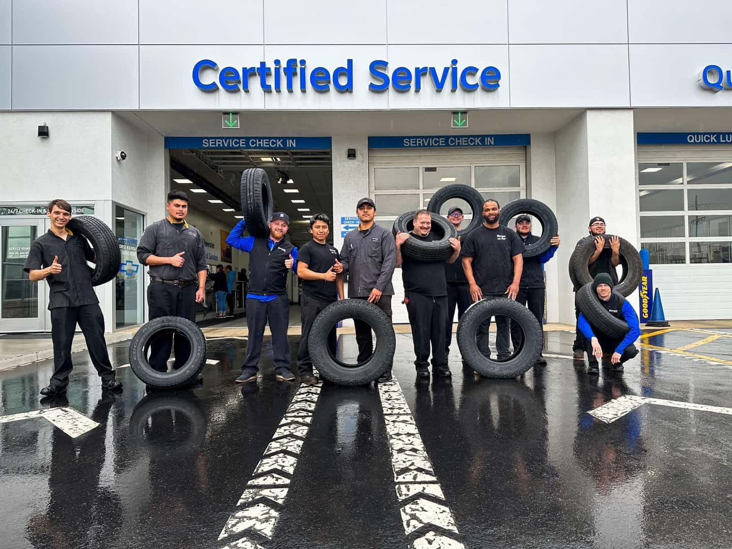 men holding tires outside of the service department