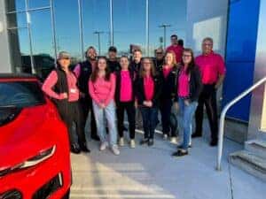 Berger Chevy employees taking a group photo in Breast Cancer Awareness apparel