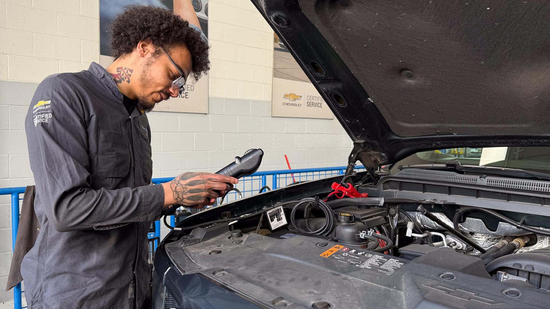 man testing battery under the hood