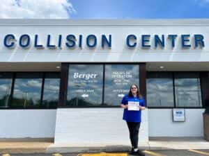 Sarah with her Employee Spotlight Certificate in front of the Collision Center