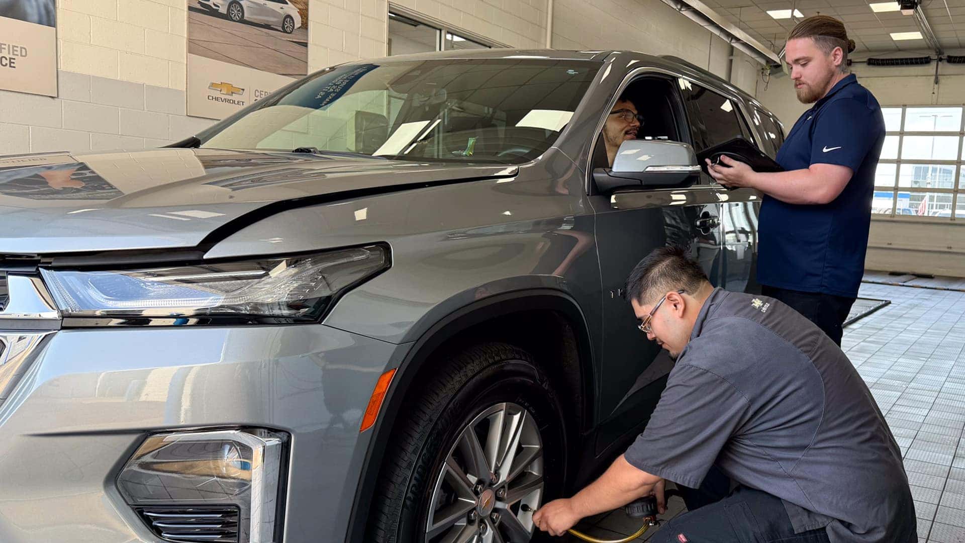 tech checking tire pressure