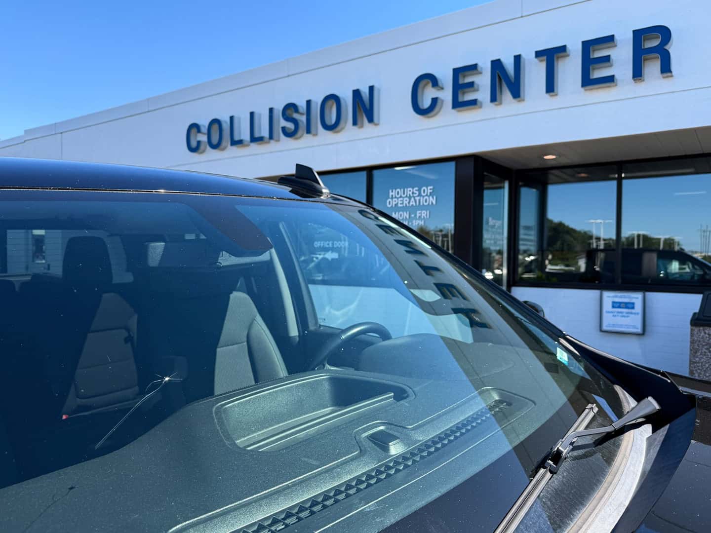 Damaged windshield in front of Berger Collision Center