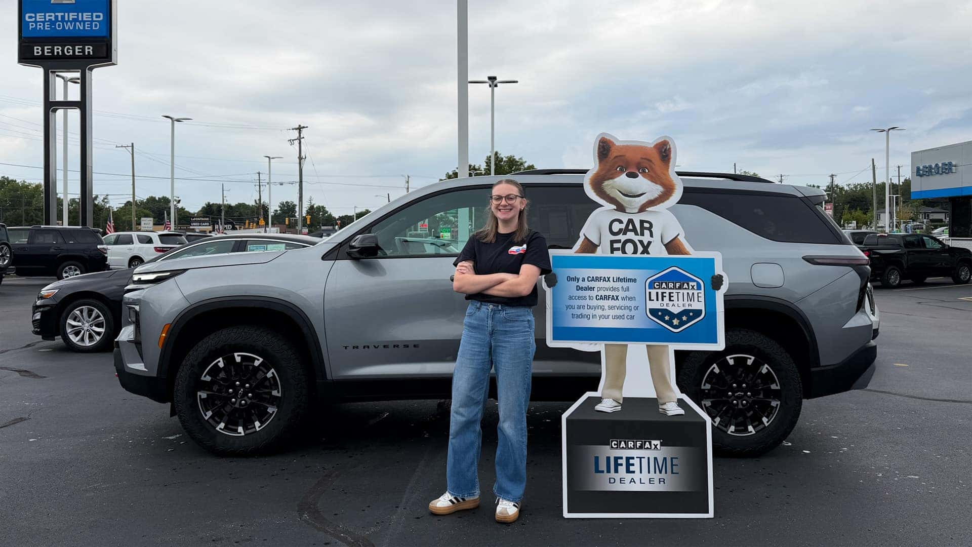 Woman with CarFax Lifetime Dealer Sign