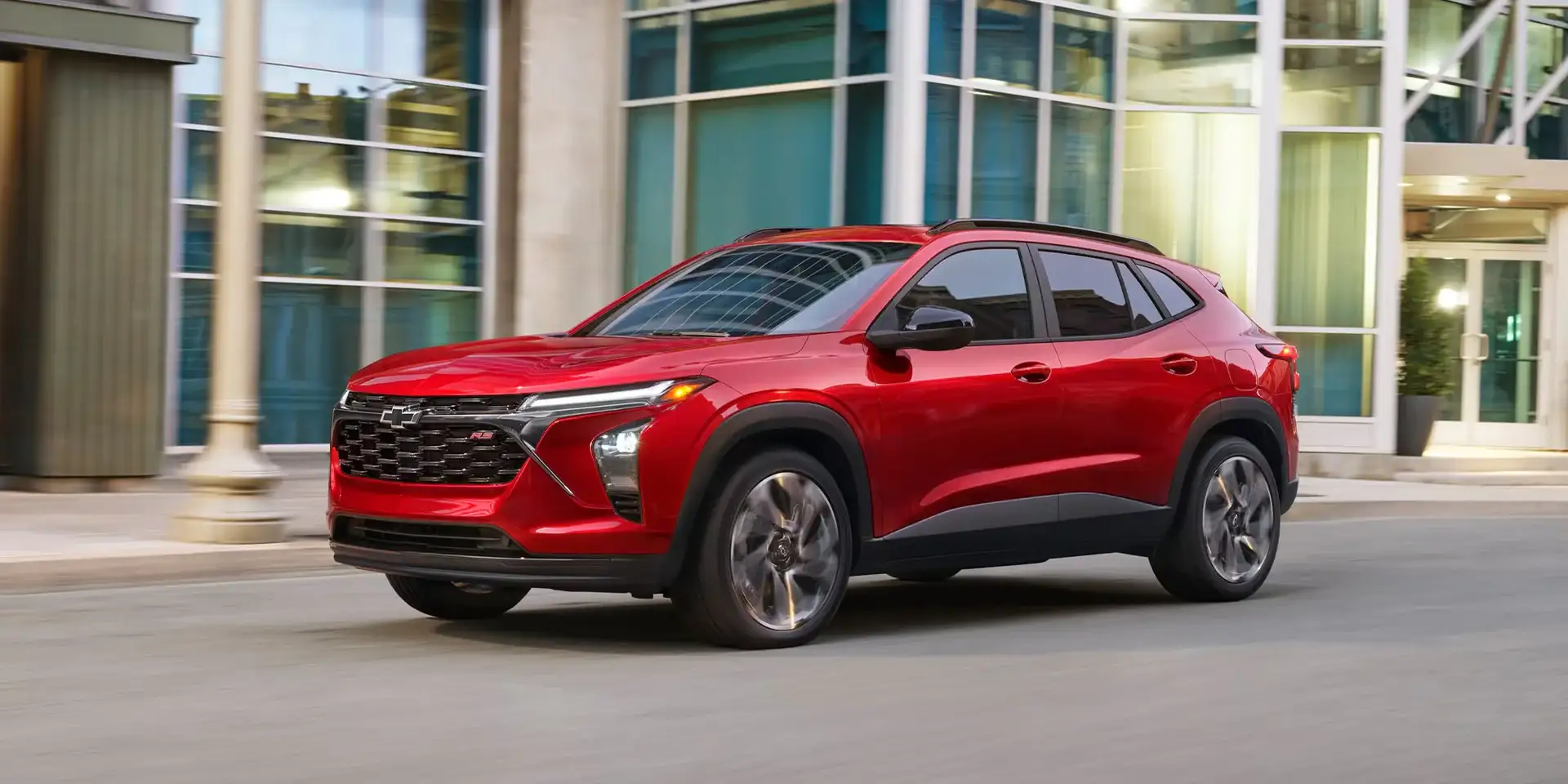 2026 Chevrolet Trax 2RS in red parked outside a glass building