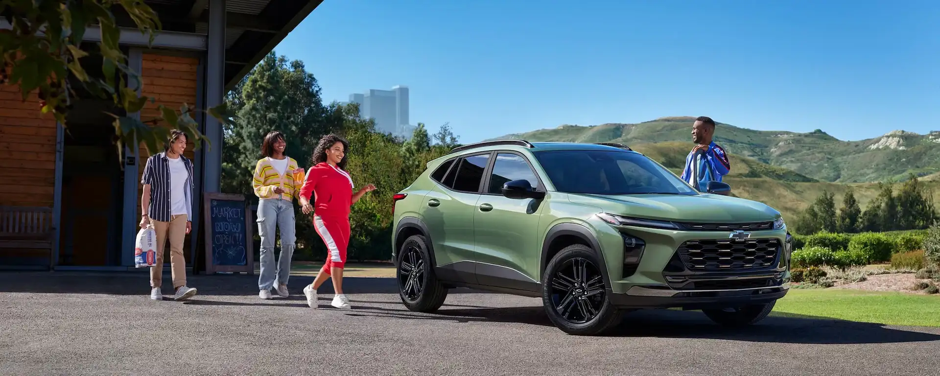 2026 Chevrolet Trax parked outside a modern building as a group of people walk toward it