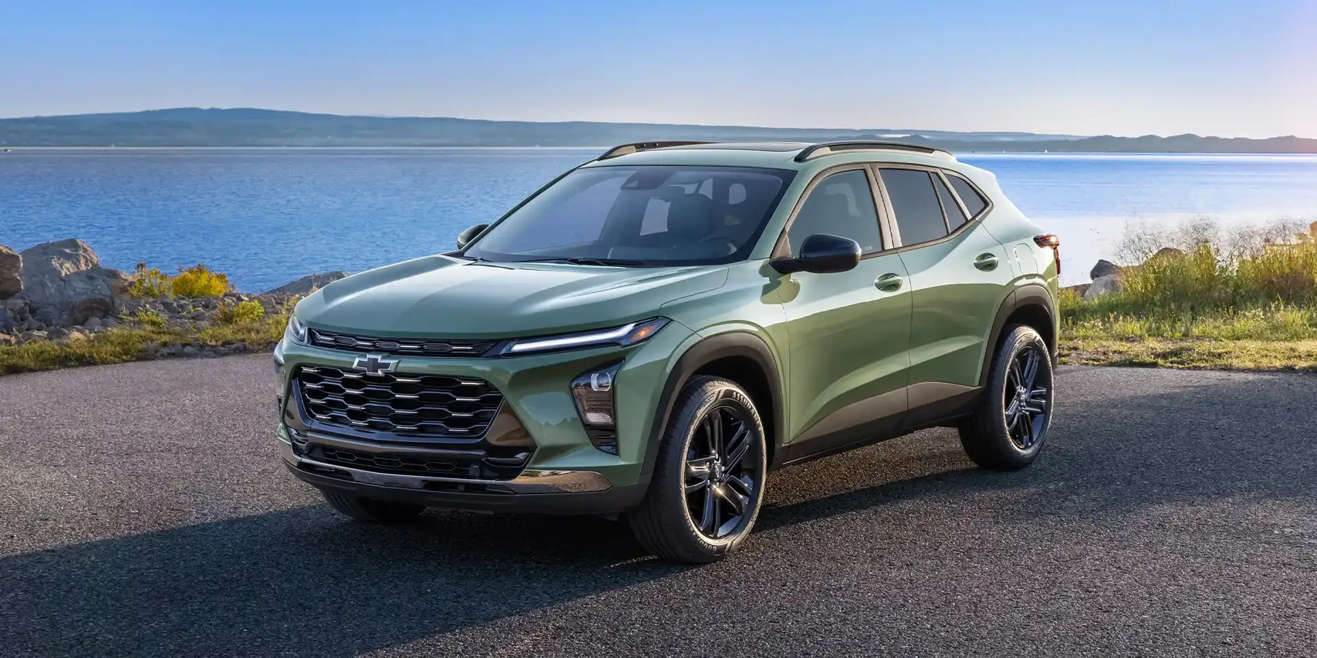 Sage green Chevrolet Trax front three-quarter view beside the water