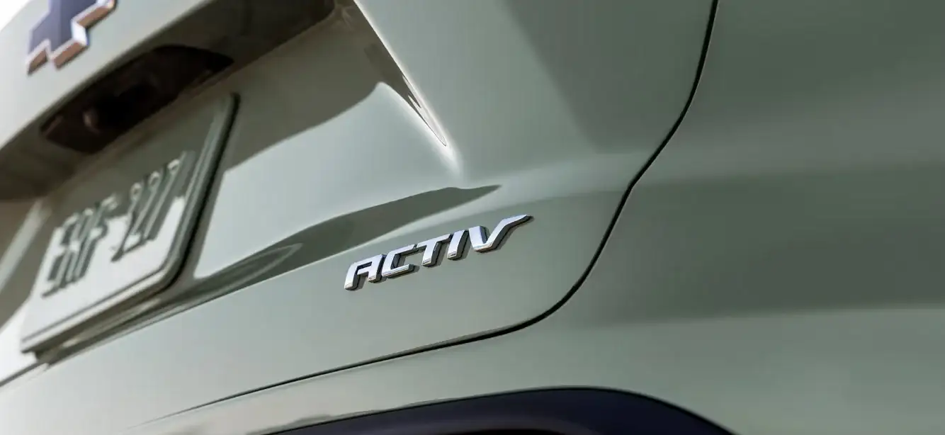 Close-up of the ACTIV badge on the rear quarter panel of a sage green Trax