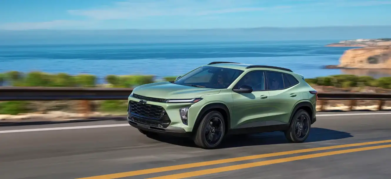 Sage green Chevrolet Trax driving along a coastal highway