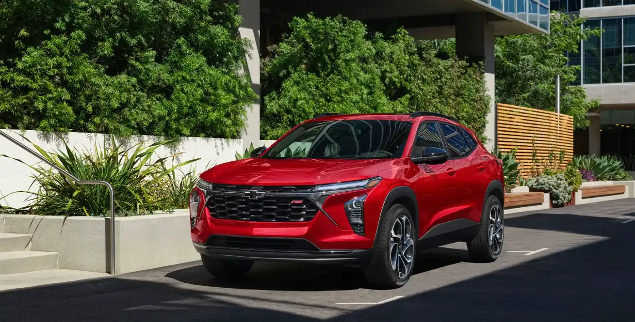 Red Chevrolet Trax parked beside landscaped planting