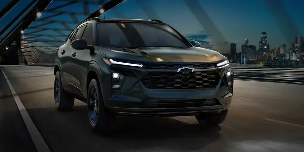 Chevrolet Trax Midnight Edition in black, front three-quarter view against a city skyline