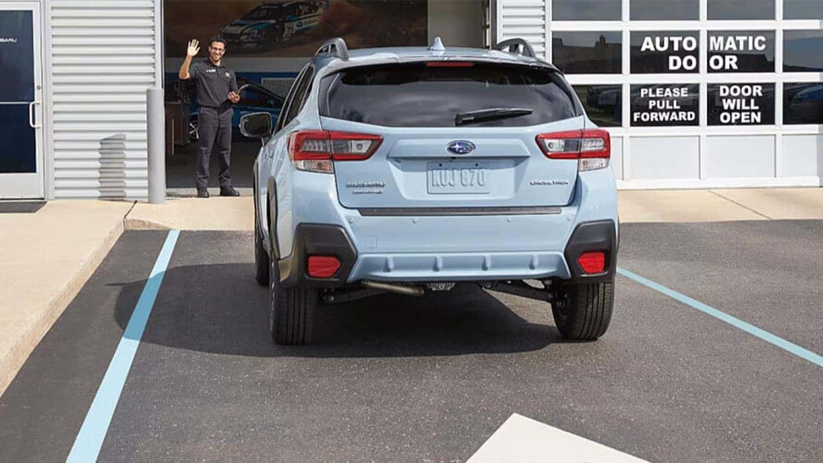 Subaru service tech welcoming a Subaru in the service bay