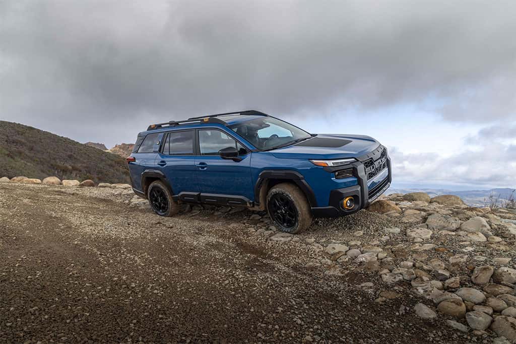 2026 Subaru Outback Wilderness driving on a rocky trail in blue