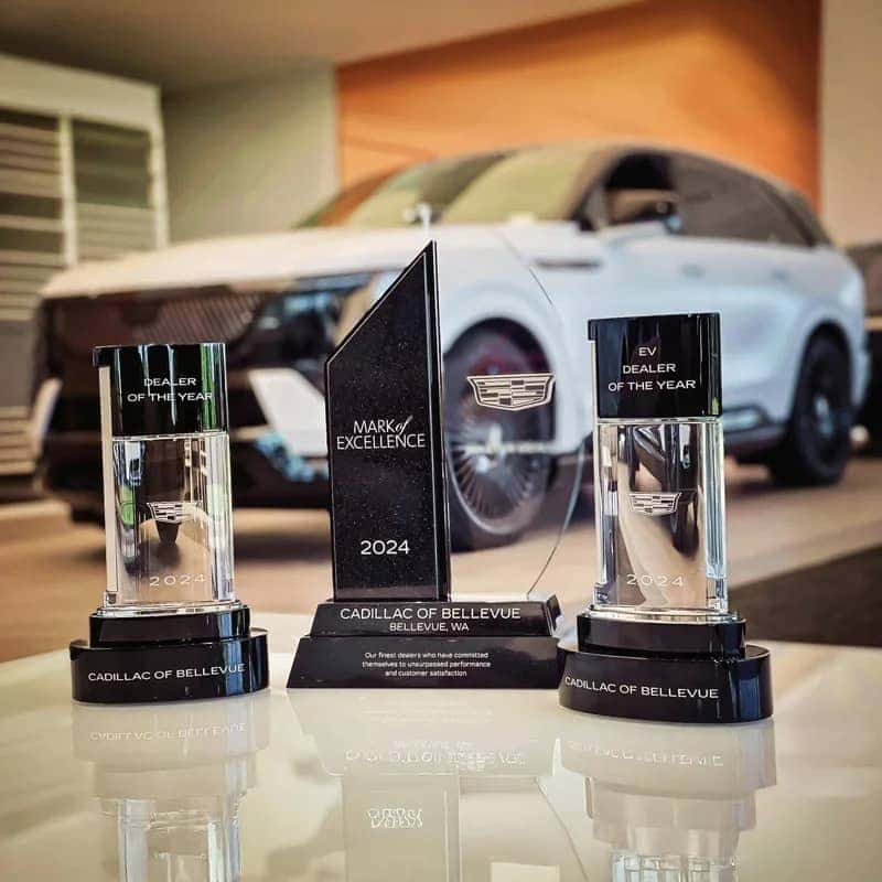 Dealer of the Year Award, Mark of Excellence Award and EV Dealer of the Year Award with an Escalade IQ in the background