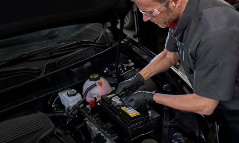 Cadillac technician replacing a car battery