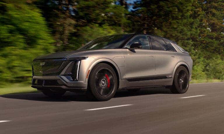 2026 Cadillac LYRIQ driving fast near forest