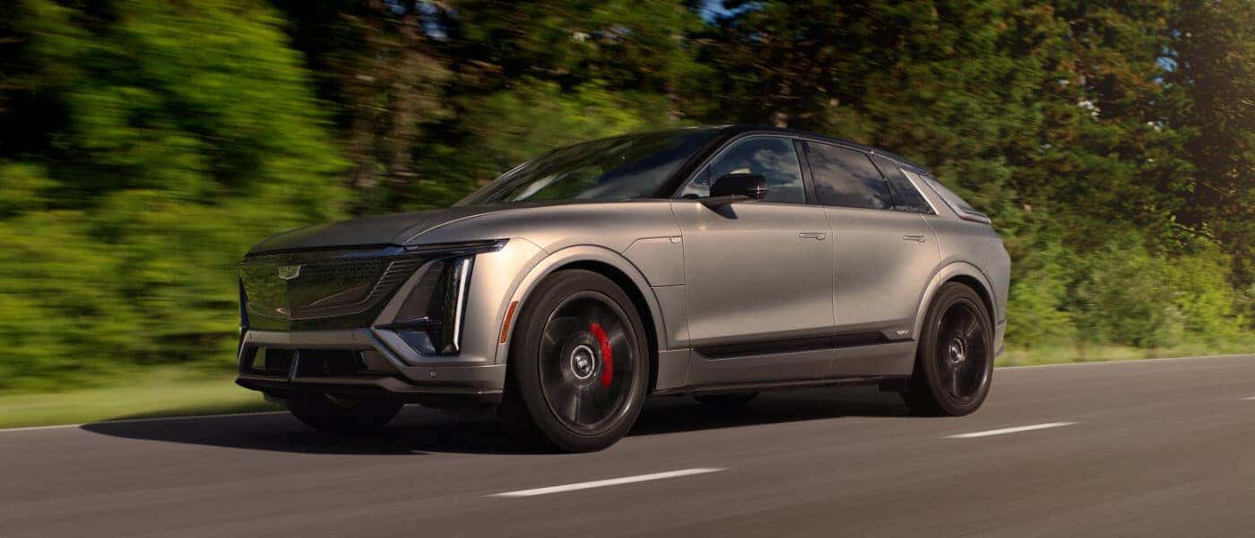 26Cadillac-LYRIQ-ExteriorDrivingNearForest