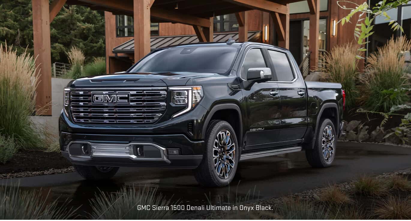 Front three-quarter view of a GMC Sierra 1500 Denali Ultimate in Onyx Black parked outside.