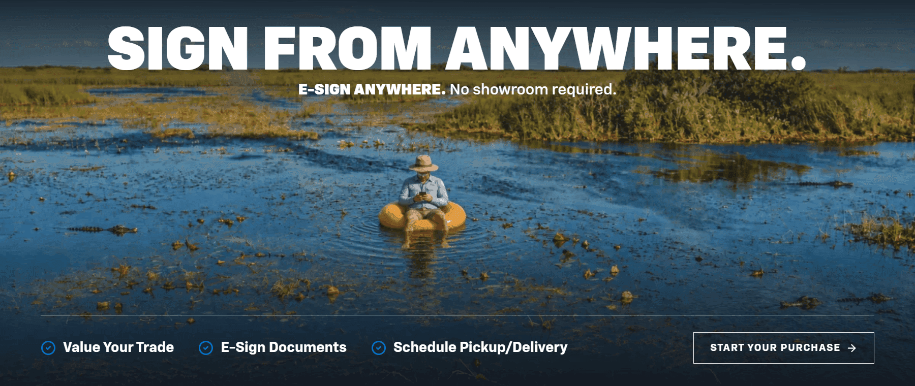 Man sitting in an inner tube in the Florida wetlands signing car purchase documents on his phone - Sign From Anywhere, Start Your Purchase online with Carl Black Buick GMC Orlando
