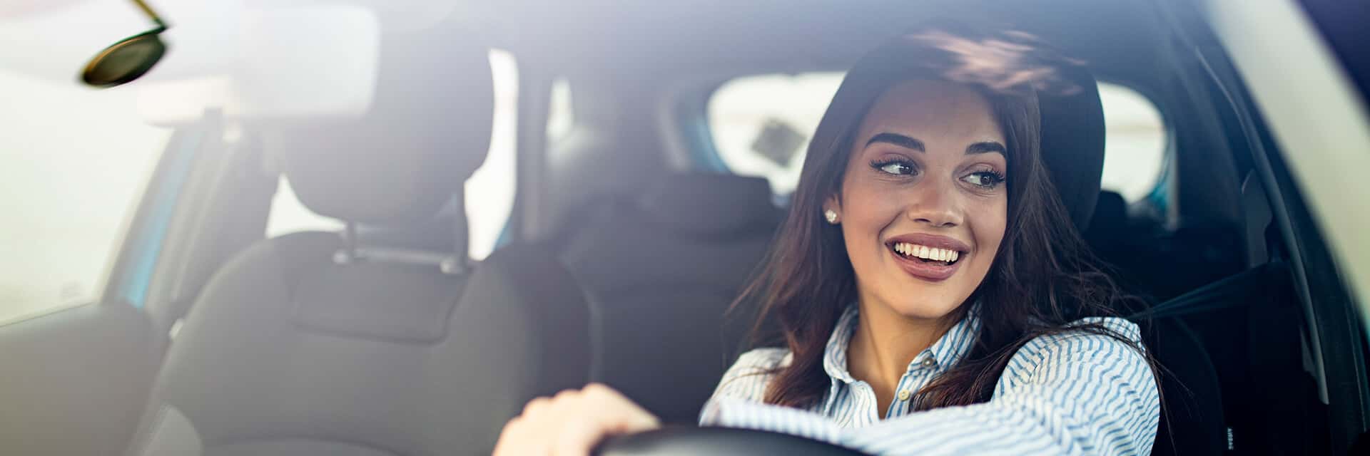 happy woman driving in front seat