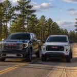 2026 GMC Sierra 1500 and 2026 GMC Canyon side by side on a longleaf-pine road in the North Carolina Sandhills near Rockingham