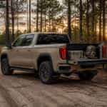 2026 GMC Sierra 1500 AT4 with open tailgate and hunting gear in a North Carolina Sandhills longleaf pine setting
