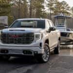 2026 GMC Sierra 1500 hitched to a boat trailer at a North Carolina boat ramp with ProGrade Trailering camera view on the infotainment screen