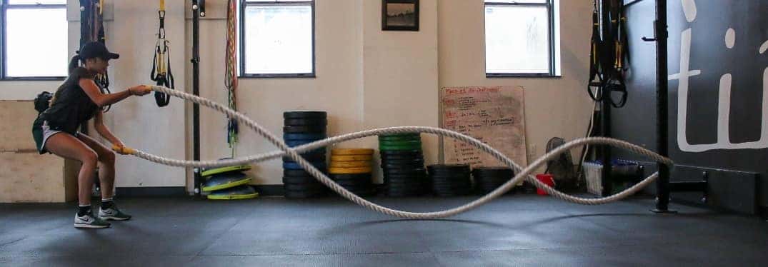 Female athlete working out with ropes