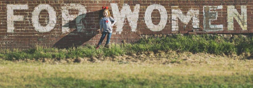 Little Girl in Front of 'For Women' Mural