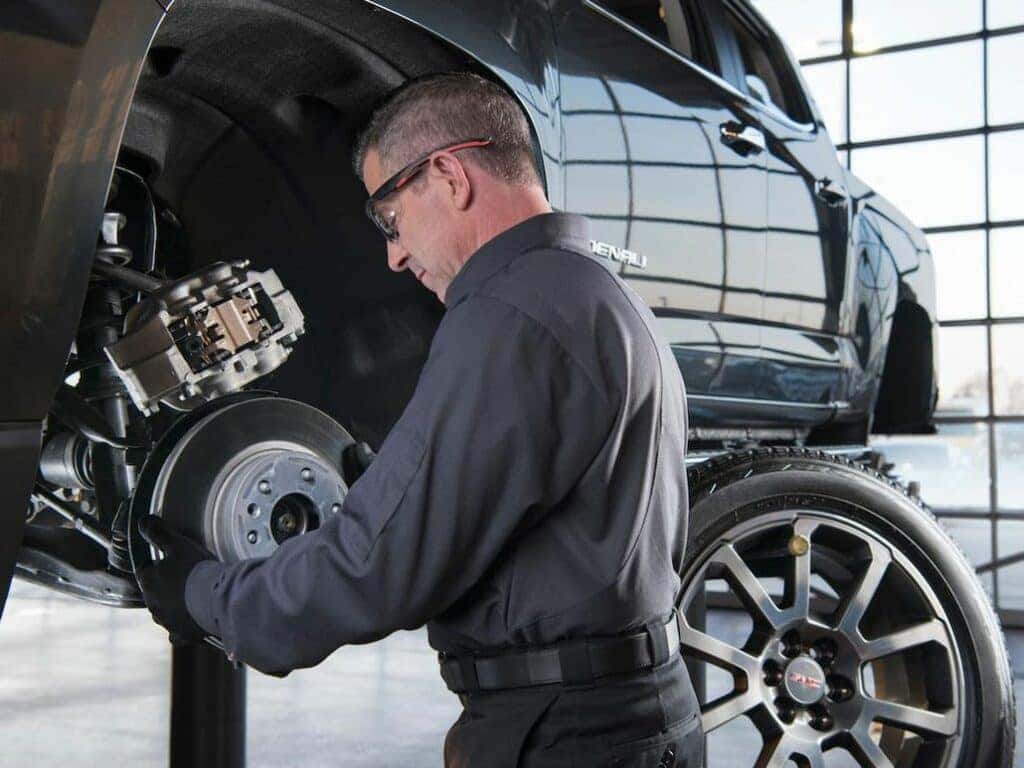 Service Professional Performing Brake Maintenance on a GMC