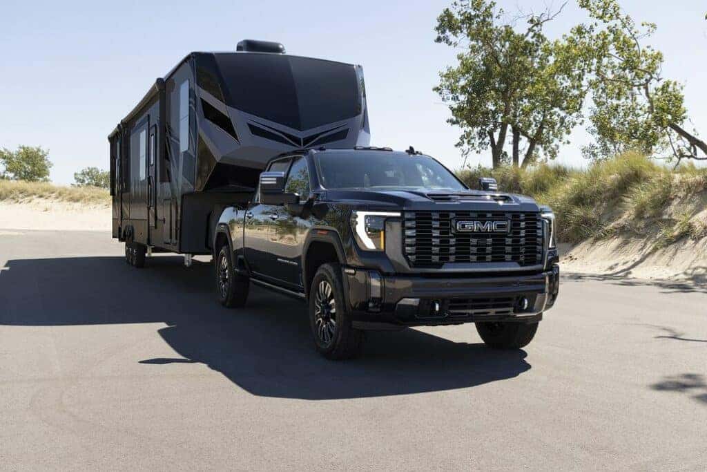 GMC Sierra 2500 HD Towing a Camper Front 3/4 View