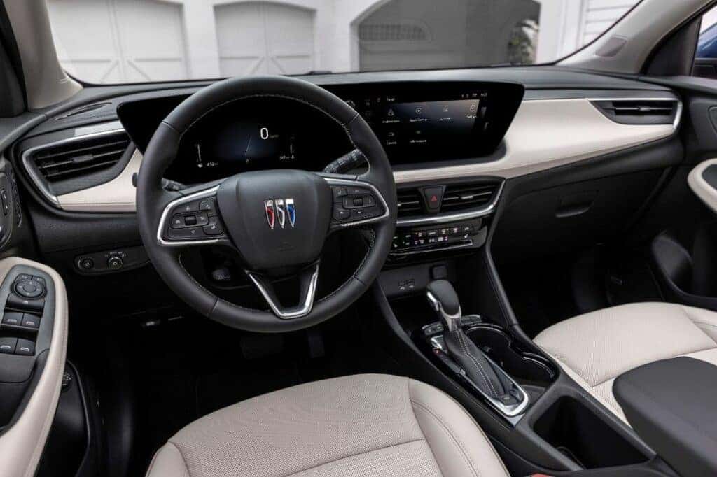 View of the driver’s seat in 2024 Buick Encore GX Avenir with Whisper Beige and Jet Black interior. Preproduction model shown. Actual production model may vary. Available in Spring 2023.