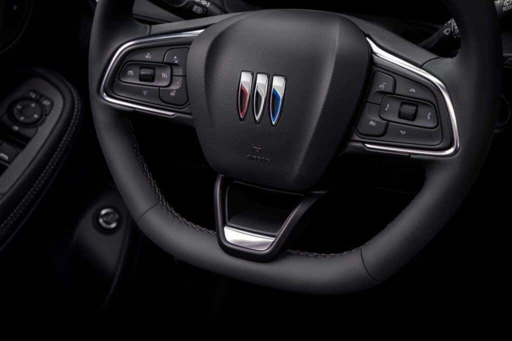 Close up view of the flat-bottom steering wheel cabin in the 2024 Buick Encore GX ST with Jet Black interior. Preproduction model shown. Actual production model may vary. Available in Spring 2023.