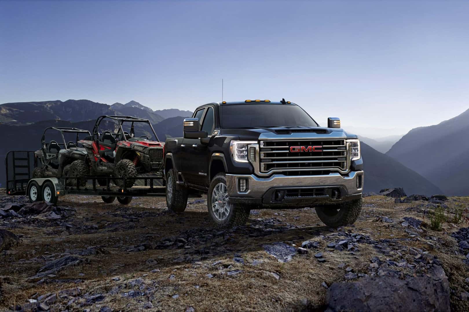 A Black 2023 GMC Sierra Towing A Heavy Haul With Diligent Tires Over Rocky Ground