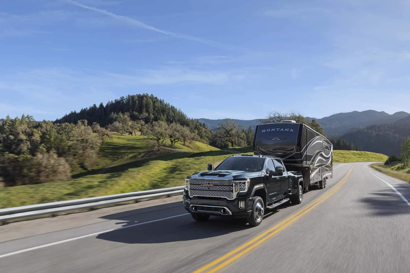 GMC Sierra 3500HD towing a fifth wheel on the road
