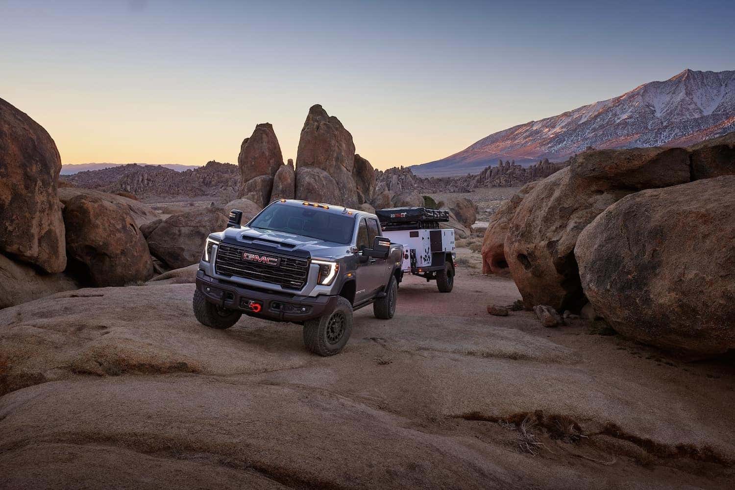 2024 GMC Sierra 2500HD AT4X AEV Edition towing an off-road trailer