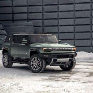 Green 2024 GMC Hummer EV front and passenger side view