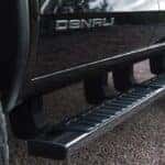 Detail view of GMC Canyon Denali assist steps with Denali logo.