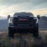The Ultimate Heavy-Duty Pickup Truck: The 2026 GMC Sierra 2500, Intimidatingly Parked In The Grass, With Huge Mountains In The Background