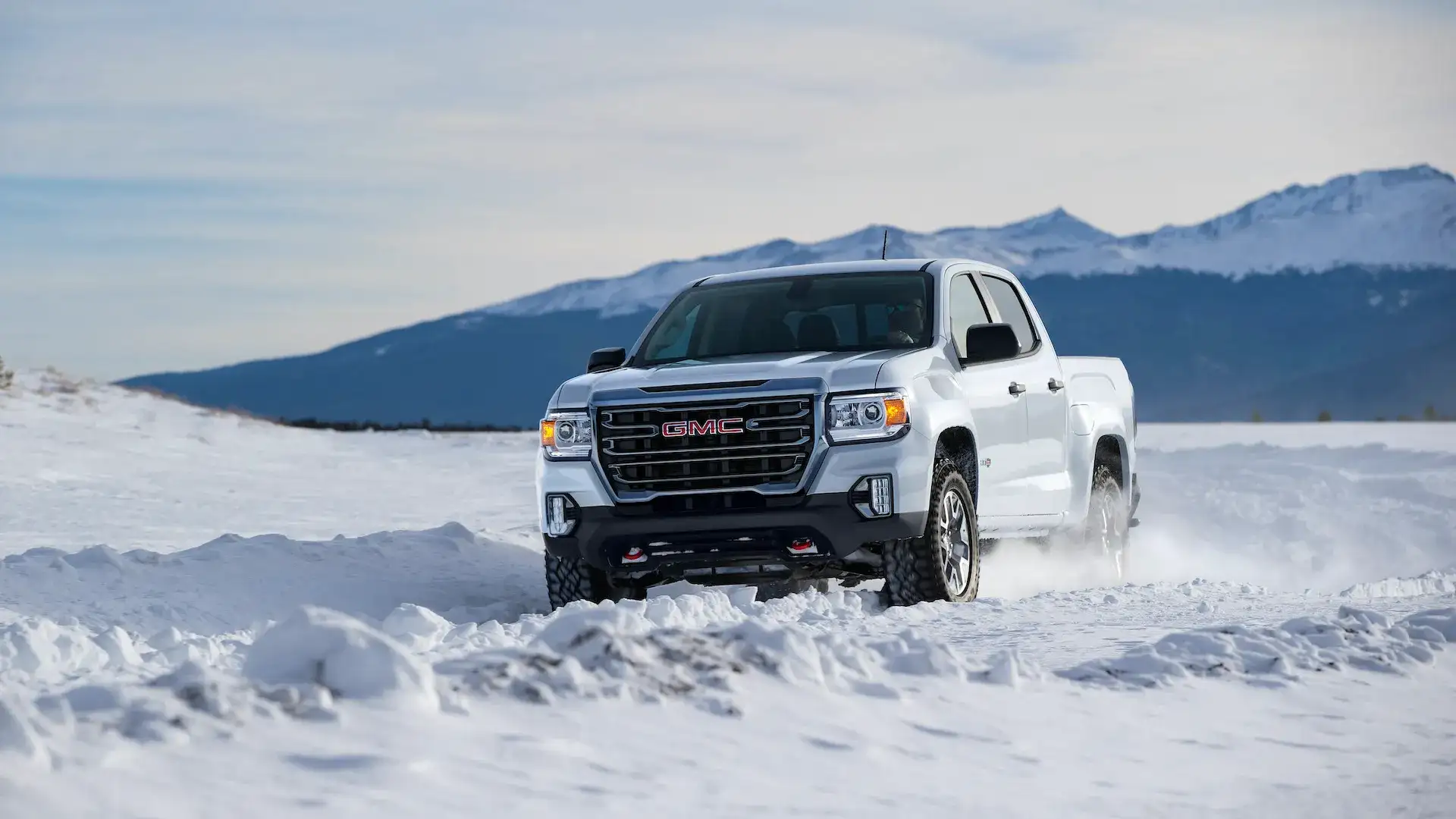 2021 White GMC Canyon AT4 driving off road in snow