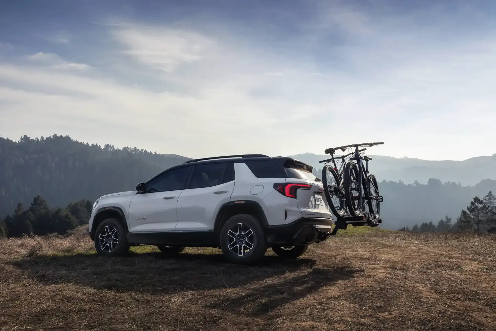 2026 GMC Terrain AT4 rear view parked off road on a mountain
