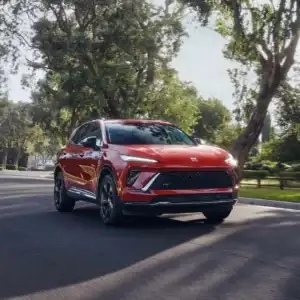 2026 Buick Envision Brilliant Red driving in a neighborhood
