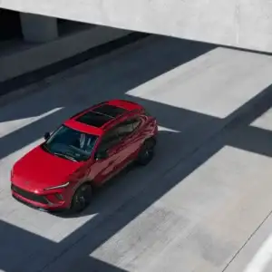 2026 Buick Envision Brillant Red driving under an overpass