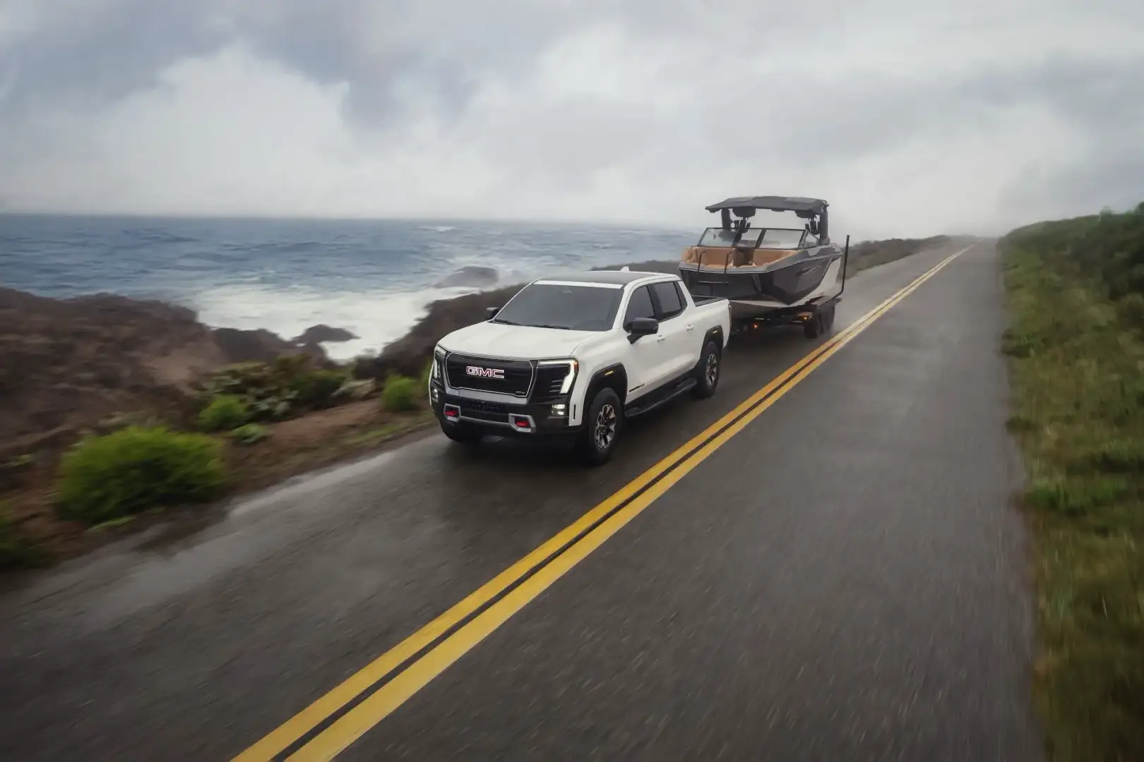 GMC Sierra EV towing a boat by the water