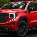 Red GMC Sierra parked off road in nature