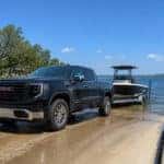 2026 GMC Sierra 1500 backing a boat trailer down a Lewisville Lake ramp on a summer morning